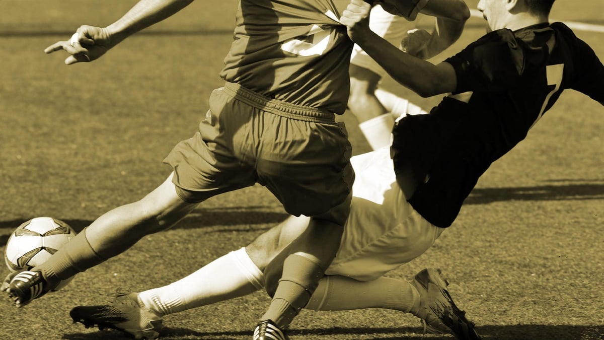 Två fotbollsspelare tävlar om bollen